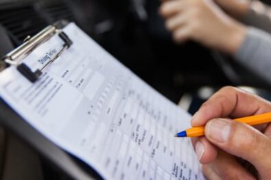 Driving test examiner making notes