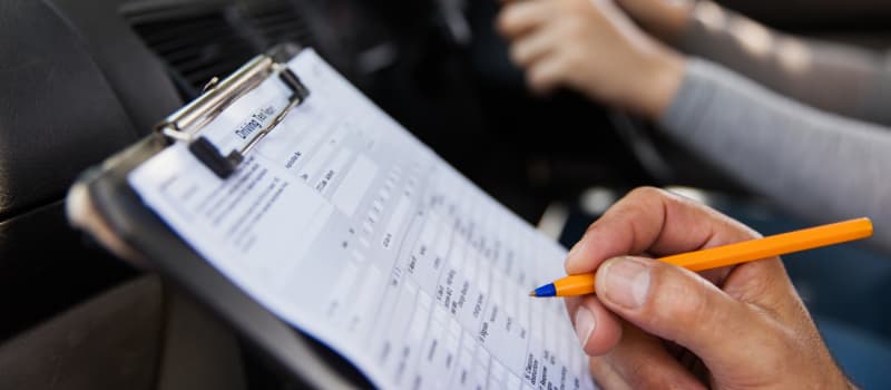 Driving test examiner making notes