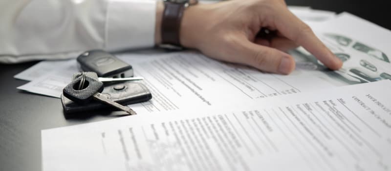 Man signing Car Insurance documents