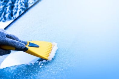 Someone cleaning icy windscreen wiper