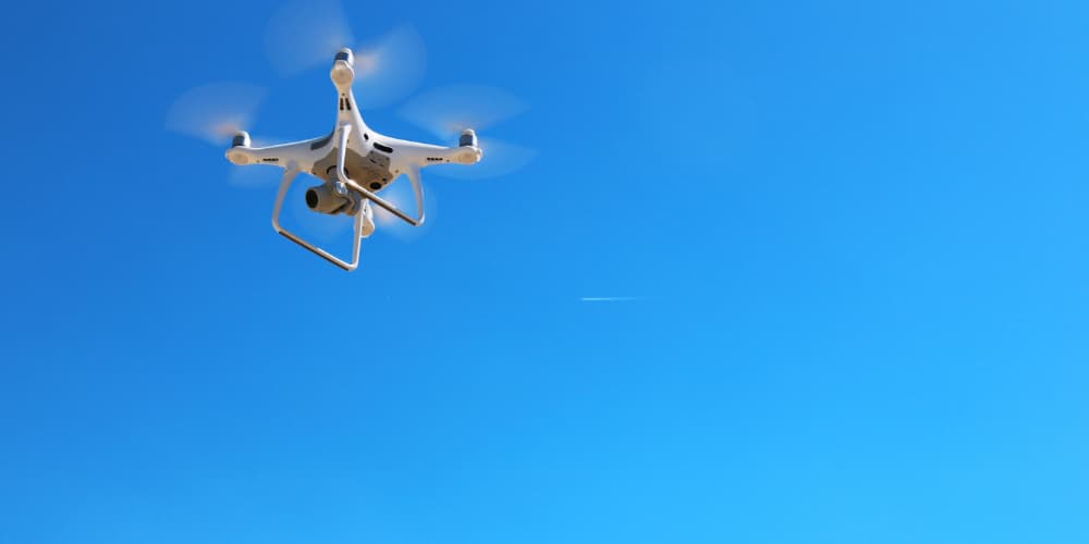 Drone flying in clear blue sky